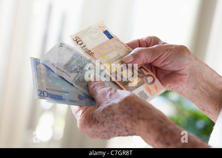 Dettaglio di una donna senior azienda banconote europee Foto Stock