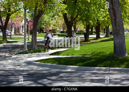 Ragazzo Bicicletta Equitazione sul sentiero tra gli alberi sul ciglio della strada Foto Stock