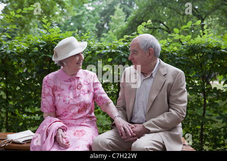 Romantico coppia senior su banco nel parco Foto Stock