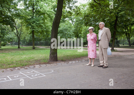 Coppia senior contemplare campana nel parco Foto Stock