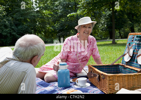 Coppia senior avente rilassante picnic nel parco Foto Stock