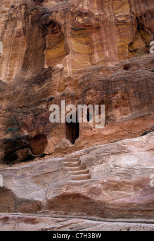 Medio Oriente, Giordania, Petra, vista esterna della grotta sul lato scogliera e scolpiti passi Foto Stock