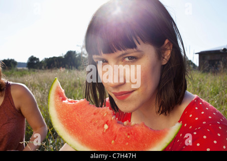 Ragazza ha fetta di melone nella sua mano con marchi di bici su di esso Foto Stock
