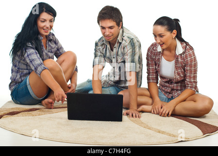 Happy amici seduti sul tappeto e di essere stupito lo schermo del notebook su sfondo bianco Foto Stock