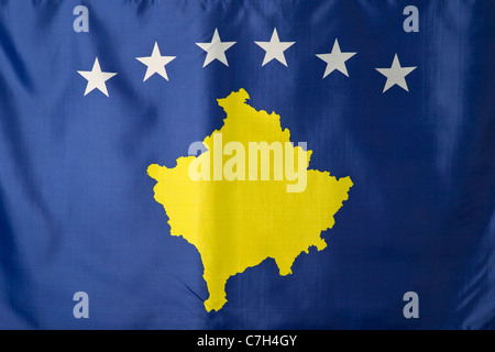 Il Kosovo, bandiera blu con un oro oggetto mappa del Kosovo sotto un arco di sei stelle bianche Foto Stock