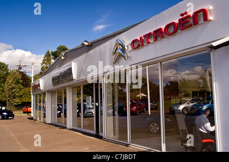 Riflessioni sui vetri anteriori di Ian Fleming Citroen auto showroom in una giornata di sole in ambiente urbano Dundee,UK Foto Stock