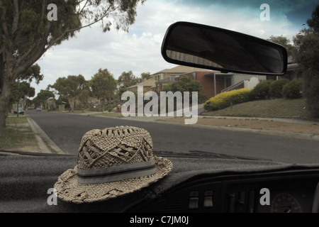 Cappello di paglia seduta sul cruscotto di automobile Foto Stock