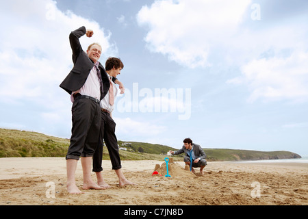 Imprenditori costruire castelli di sabbia Foto Stock