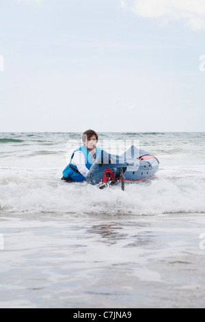 Imprenditore spingendo la canoa in ocean Foto Stock