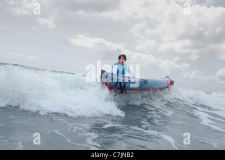 Imprenditore spingendo la canoa in ocean Foto Stock