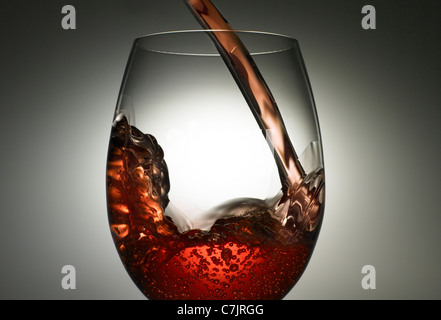 Close up di vino versando in vetro Foto Stock