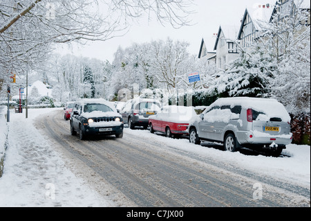 Strada del villaggio invernale (condizioni di guida innevate, viaggi in jeep, auto parcheggiate su strada, marciapiede innevato) - Burley a Wharfedale, Inghilterra, GB, UK. Foto Stock