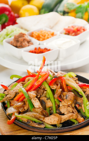 Originale sfrigolanti fajita fumante servita sulla piastra di ferro e verdure fresche su sfondo ,più cibo delizioso sul portafoglio Foto Stock