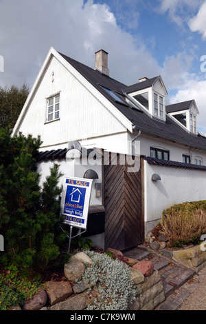 Restaurato, bianco casa di pescatori in vendita sulla strada costiera in Rungsted, Danimarca. Agente immobiliare per la vendita al di fuori del segno. Foto Stock