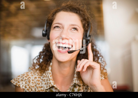 Donna sorridente indossando le cuffie Foto Stock