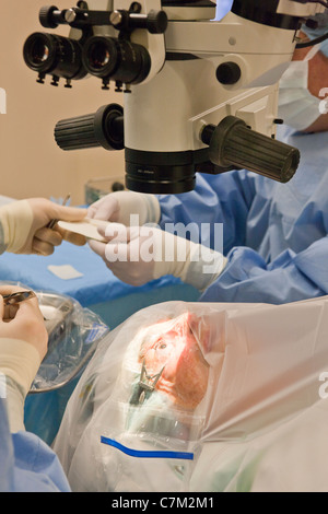 Tecnologo chirurgico passando sutura al medico per la chirurgia della cataratta Foto Stock