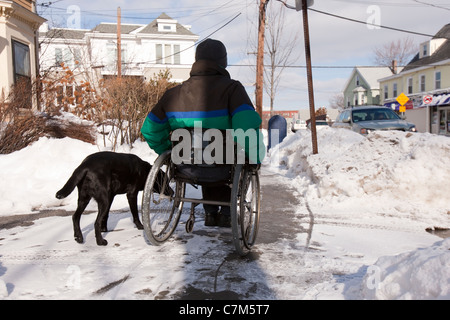 Donna con sclerosi multipla cercando di raggiungere la casella di posta con un cane di servizio Foto Stock