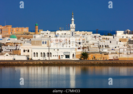 Le case bianche della città portuale Sur tra la laguna blu e il Golfo di Oman, il sultanato di Oman Foto Stock