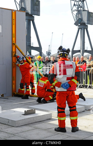 Urban Search & Rescue Vigili del Fuoco squadre & essendo valutati in UK Rescue sfida evento erigendo temp unità di puntellamento centro Excel London REGNO UNITO Foto Stock