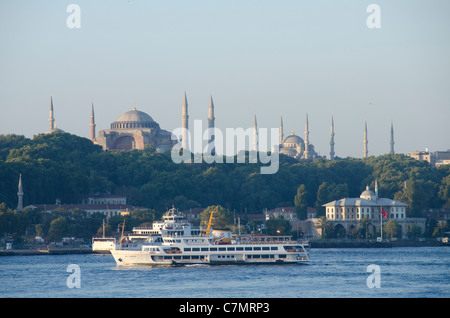 Turchia, Istanbul. Istanbul skyline della città con acqua locale taxi, traghetto. Hagia Sophia e la Moschea Blu in distanza. Foto Stock