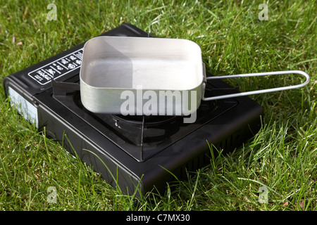 Di piccole dimensioni di gas portatile camping fornelli di acqua bollente in un pasticcio di alluminio stagno Foto Stock