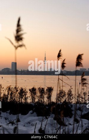 Saldamente Aussenalster congelato, Esterno lago Alster, dopo il tramonto, persone, divertimenti, ghiaccio, neve, in inverno, Amburgo, Germania Foto Stock