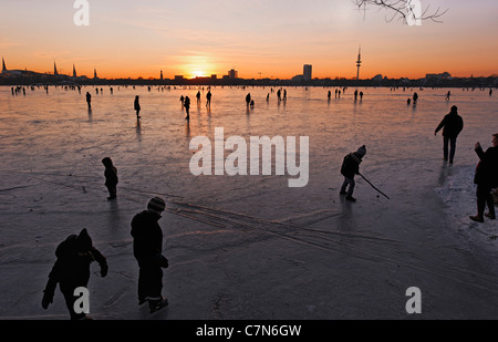 Saldamente Aussenalster congelato, Esterno lago Alster, dopo il tramonto, persone, divertimenti, ghiaccio, neve, in inverno, Amburgo, Germania Foto Stock