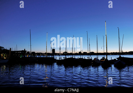 Barche a vela, i montanti con illuminazione posteriore al tramonto sull'esterno lago Alster, città anseatica di Amburgo, Germania, Europa Foto Stock