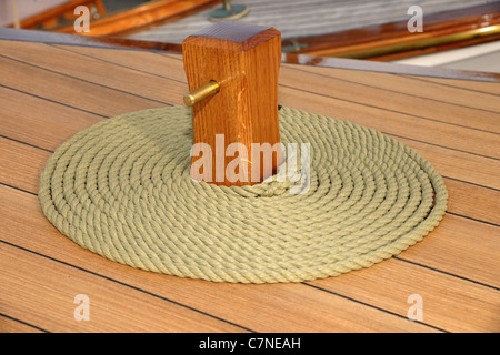 La corda avvolta sul ponte in teak. Avvolgimento decorativo è chiamato "cheesing' o 'bobina fiamminga' e stato usato per aiutare la corda a secco. Foto Stock