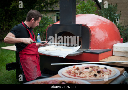 Mobile a legna per pizza forno in uso a un evento Foto Stock
