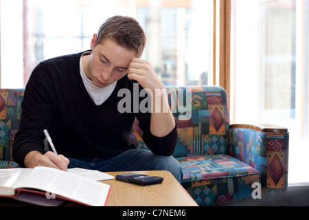 Un giovane studente di college cramming prima i suoi esami finali. Foto Stock