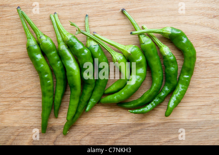 Peperoncini verdi su una quercia tagliere. Foto Stock