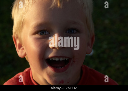 Un giovane bambino ragazzo biondo facendo una emozione divertente volto - Ritratto Foto Stock