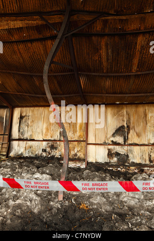 Scena di un fienile fuoco, che mostrano danni termici al RSJ e tetto. Foto Stock