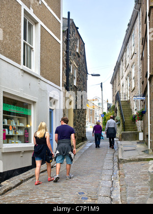 I turisti a piedi attraverso strade strette in St Ives in Cornovaglia Foto Stock