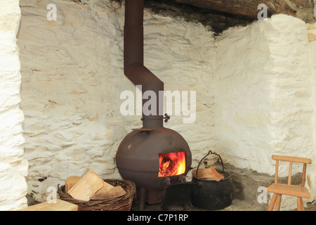 Un vaso panciuto stufa in un tradizionale caminetto irlandese, nella contea di Kerry, Repubblica di Irlanda Foto Stock