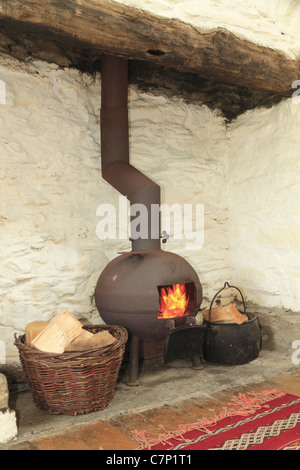 Un vaso panciuto stufa in un tradizionale caminetto irlandese, nella contea di Kerry, Repubblica di Irlanda Foto Stock