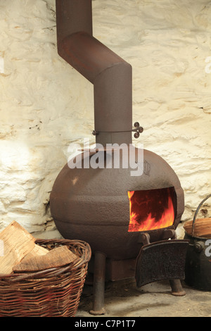 Un vaso panciuto stufa in un tradizionale caminetto irlandese, nella contea di Kerry, Repubblica di Irlanda Foto Stock