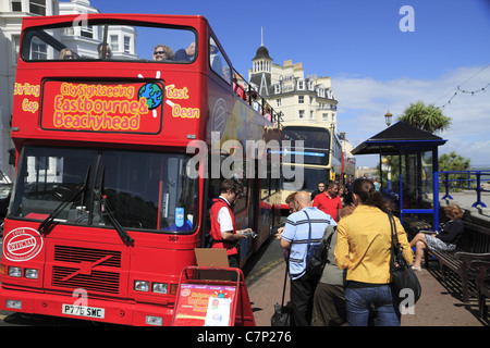 I passeggeri a bordo di un City Sightseeing a sommità aperta bus rosso a Eastbourne, East Sussex, Inghilterra. Foto Stock