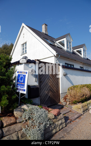 Restaurato, bianco casa di pescatori in vendita sulla strada costiera in Rungsted, Danimarca. Agente immobiliare per la vendita al di fuori del segno. Foto Stock