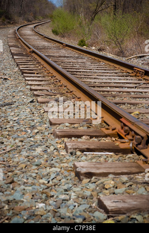 I binari della ferrovia della curvatura fuori nella distanza avanti. Foto Stock