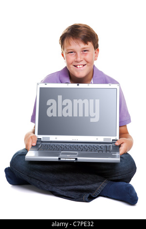 Un ragazzo di 11 anni con un computer portatile, isolato su bianco con percorso di clipping per la schermata vuota. Foto Stock