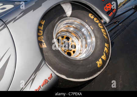 Un grande pneumatico slick pneumatico avvolti intorno ad un lucido ruota in lega su un drag racing car. Foto Stock