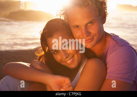 Giovane costeggiata sulla spiaggia al tramonto Foto Stock