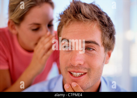 Donna whispering nell uomo l orecchio Foto Stock