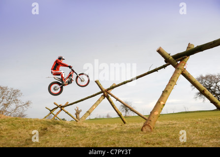 Prove di moto rider Steve Colley a Carswell Golf Club, Oxfordshire ricreando Steve McQueen il famoso Salto dal grande es Foto Stock