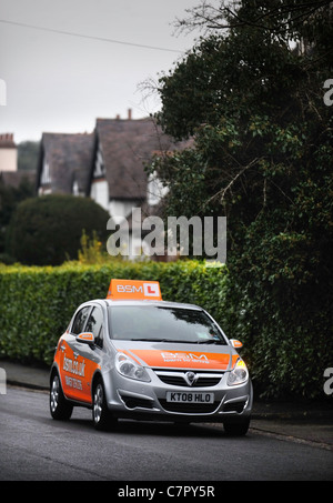 Una soluzione BSM istruttori di guida auto in una tipica strada suburbana in Inghilterra UK con caratteristica 'Mock Tudor' case Foto Stock