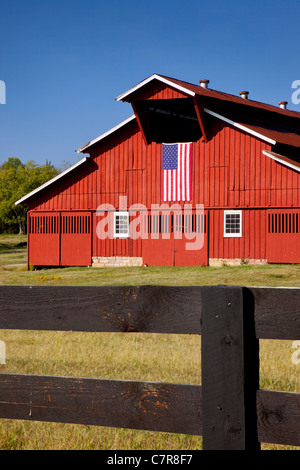 Granaio rosso con bandiera americana vicino a Franklin nel Tennessee Foto Stock