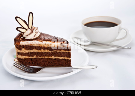 Tre strati di torta al cioccolato con caffè caldo Foto Stock