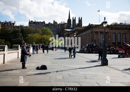 L'uomo bagpiper giocando bagpipes su Street di Edimburgo, Scozia iconico vista suonatore di cornamusa scozzese in kilt musicista di strada Foto Stock